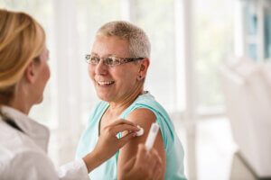 Senior woman receiving flu shot at the doctor's office.