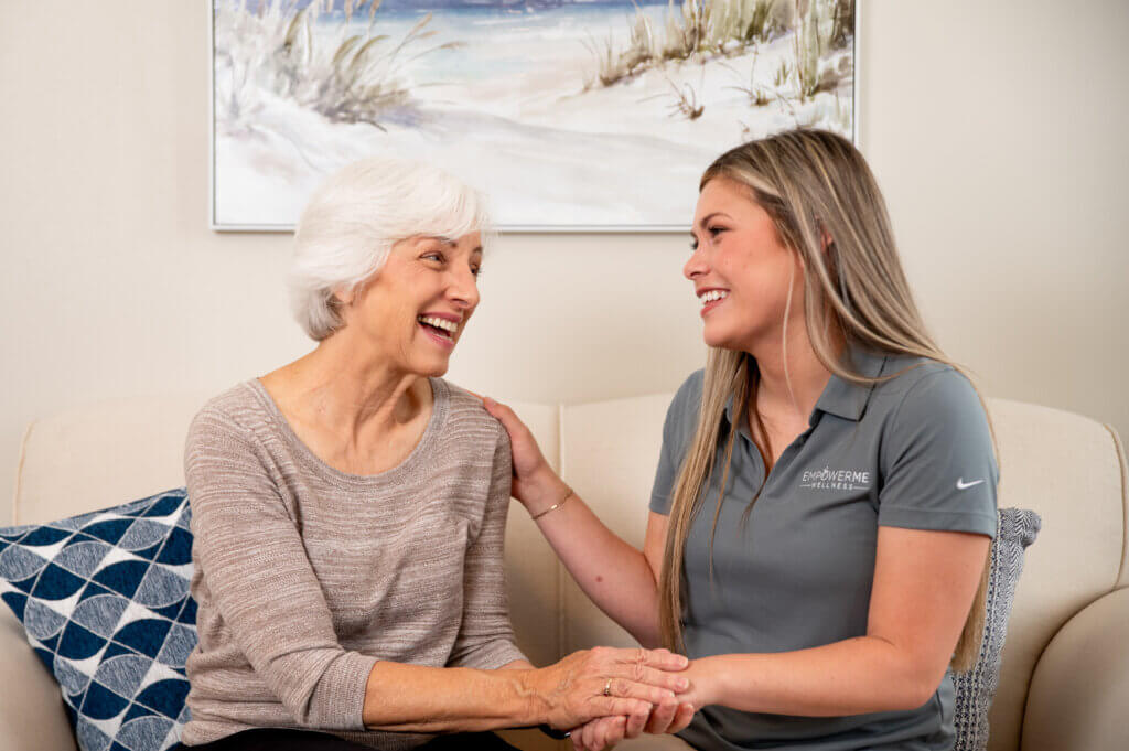 Physical therapist and senior women patient engaging in friendly conversation.