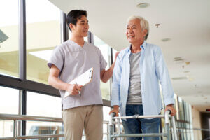 Happy senior man talking to physical therapist in rehab clinic