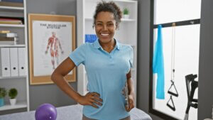 Smiling,Woman,Therapist,Holding,Clipboard,In,A,Well-equipped,Physical,Therapy