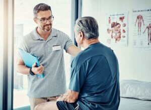 A male therapist engages in a conversation with a male senior resident, discussing care strategies and addressing concerns, illustrating how to deal with difficult patients.
