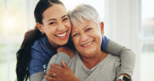Care team hugs senior patient, emphasizing support, trust, and quality dementia care in a senior living community