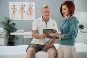 A therapist talks with a senior patient, highlighting the role of EmpowerMe 360 in preventing hospital readmissions through personalized, team-based care.