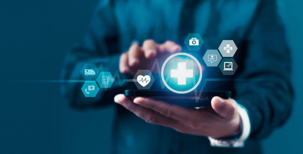 A man is holding a smartphone with a blue screen that has a heart and a cross on it