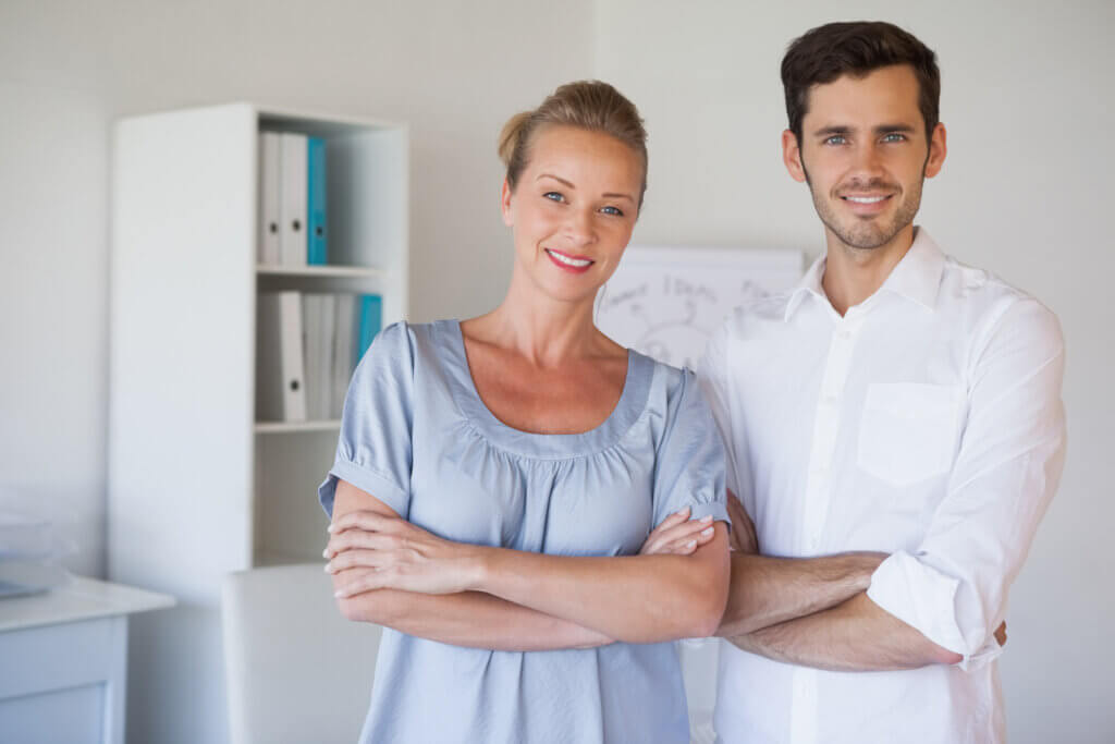 Therapy team smiling at camera with arms crossed in the office