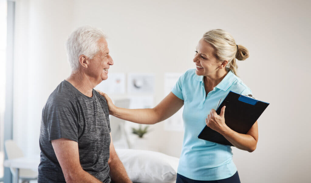 Therapists aligning professional goals with patient outcomes while working with a senior male patient